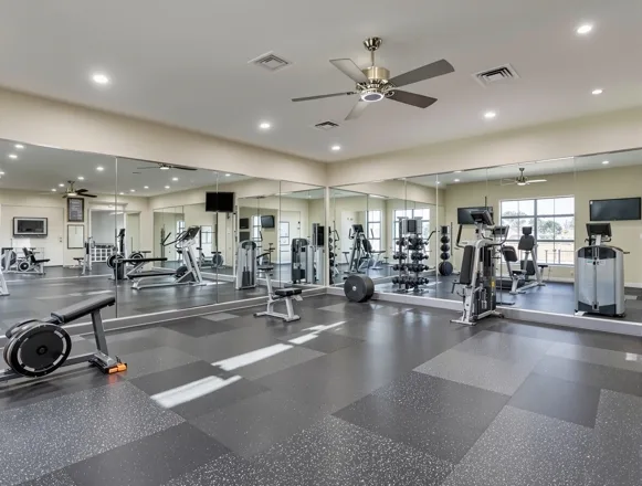Renovated fitness center — new equipment, rubber flooring, mirrors in Houston apartment community